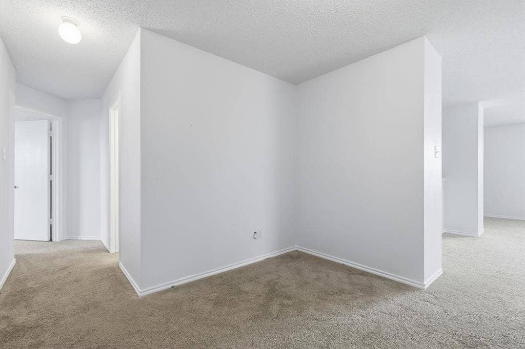 1633 Sierra Meadow Lane, Fort Worth, TX 76247 Neutral interior space featuring textured ceilings, light-toned carpeting, and minimalist walls