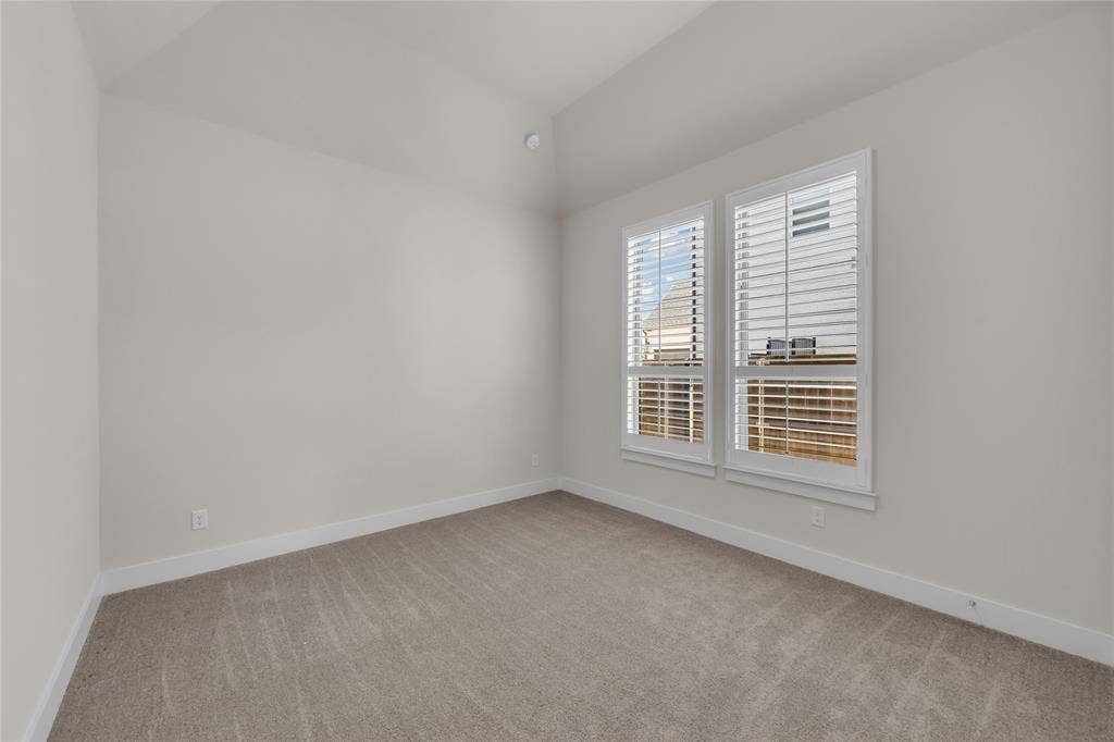 2971 Gaulding Drive, Prosper, TX 75078 Neutral-toned room featuring a vaulted ceiling, wall-to-wall carpeting, and double windows fitted with white plantation shutters