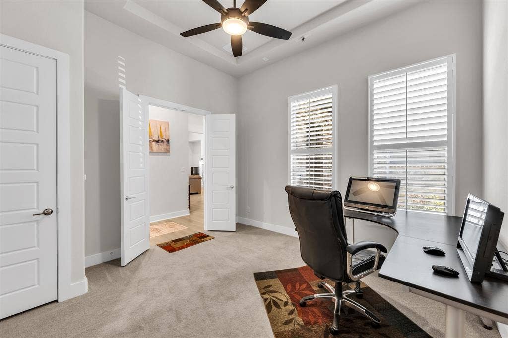 2971 Gaulding Drive, Prosper, TX 75078 Room featuring high tray ceilings, a central ceiling fan, two windows with plantation shutters, and interior doors with a five-panel design