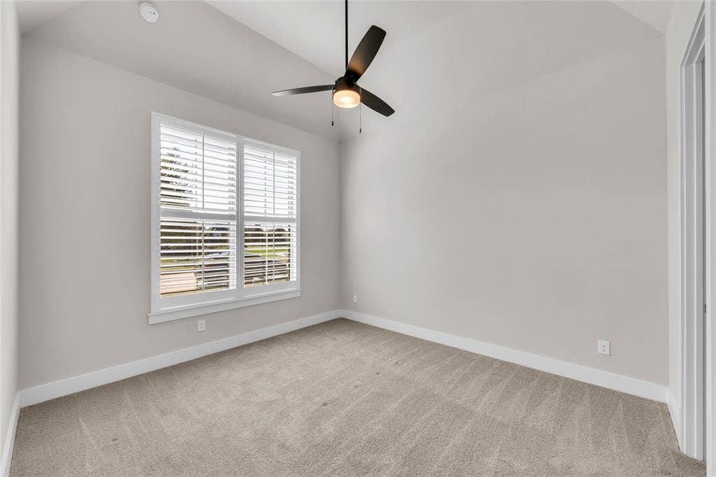 2971 Gaulding Drive, Prosper, TX 75078 Vaulted ceiling featuring a central three-blade ceiling fan with integrated lighting, window with white plantation shutters, and neutral carpeting