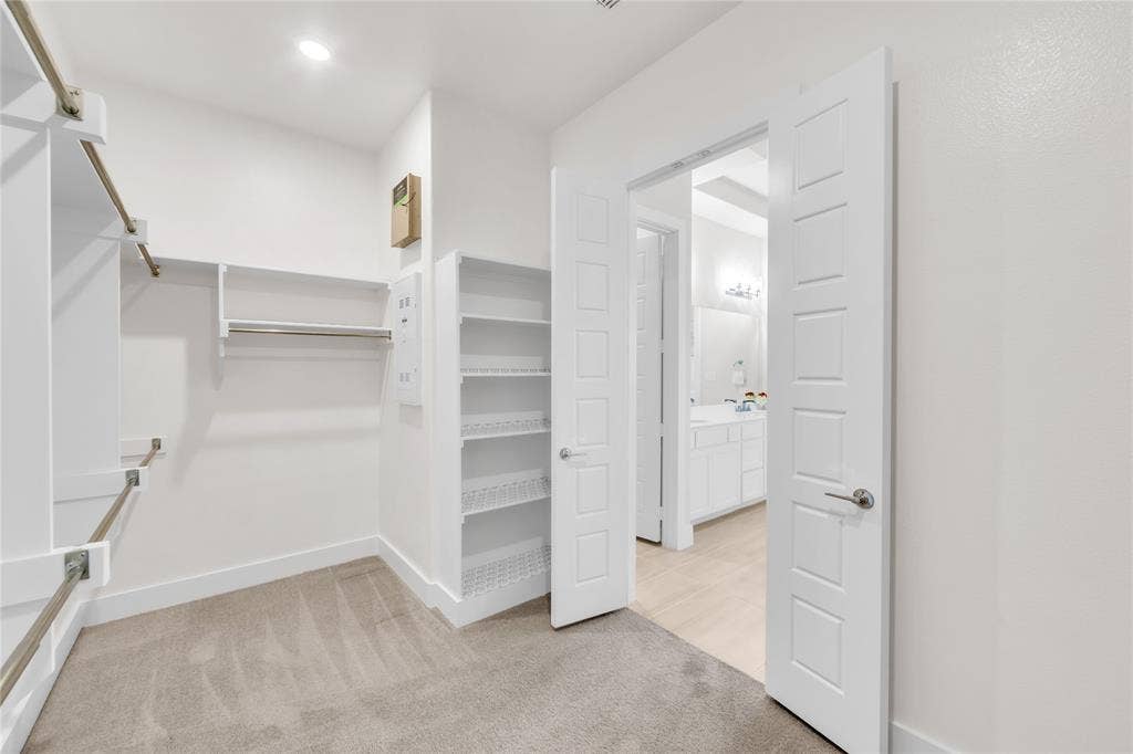 2971 Gaulding Drive, Prosper, TX 75078 Walk-in closet featuring wall-to-wall carpeting, built-in shelving, metal garment rods, and five-panel interior doors