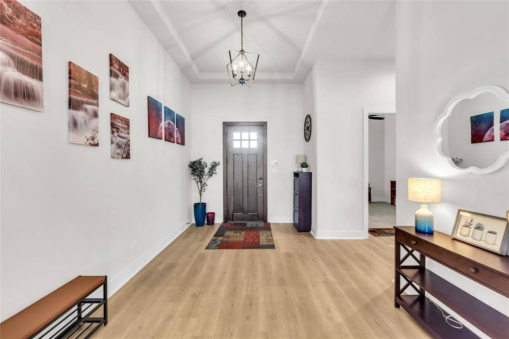 2971 Gaulding Drive, Prosper, TX 75078 Foyer featuring a recessed tray ceiling, wood-finish flooring, and a multi-light geometric pendant fixture