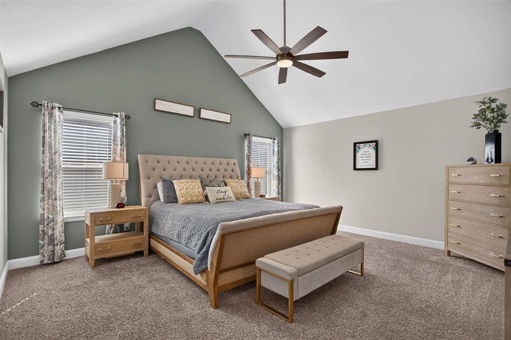 122 Anns Way, Forney, TX 75126 Vaulted ceiling featuring a central multi-blade ceiling fan, dual windows, and wall-to-wall carpeting