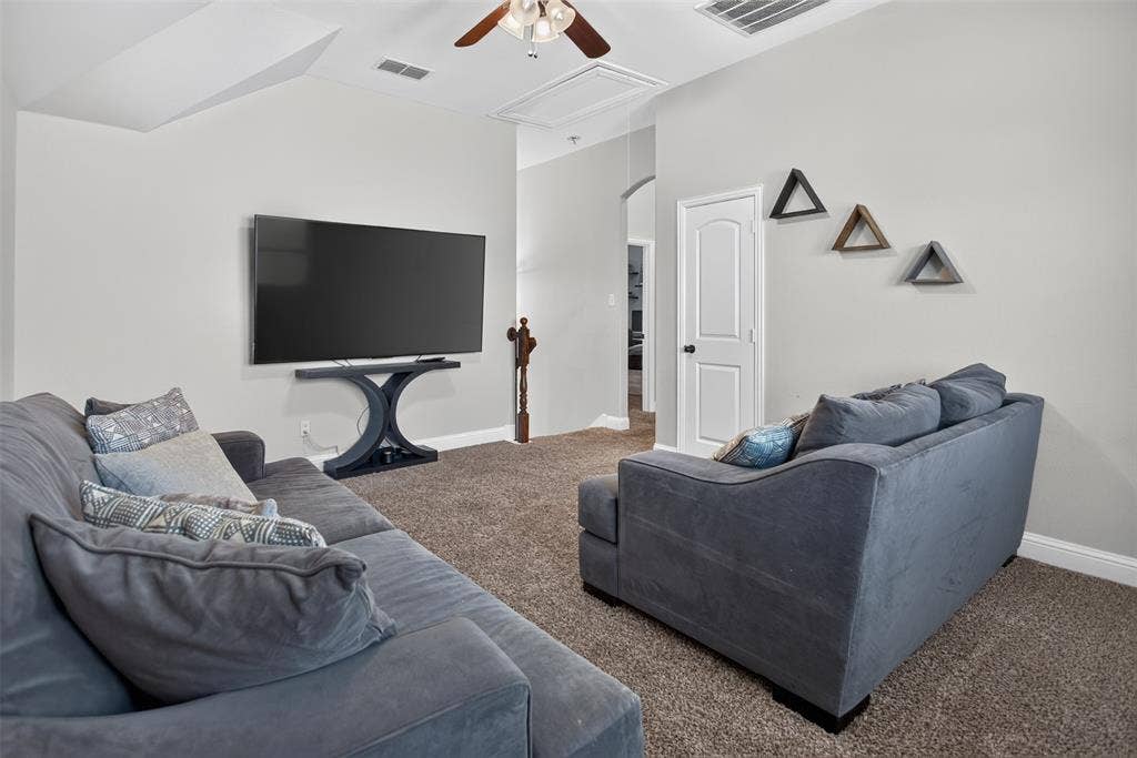 122 Anns Way, Forney, TX 75126 Neutral-toned room featuring high vaulted ceilings, wall-to-wall carpeting, an attached ceiling fan with lighting, and an arched entryway