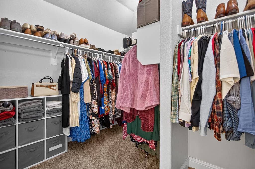 122 Anns Way, Forney, TX 75126 Walk-in closet featuring tiered clothing rods, integrated upper shelving, and custom built-in cubbies with storage bins