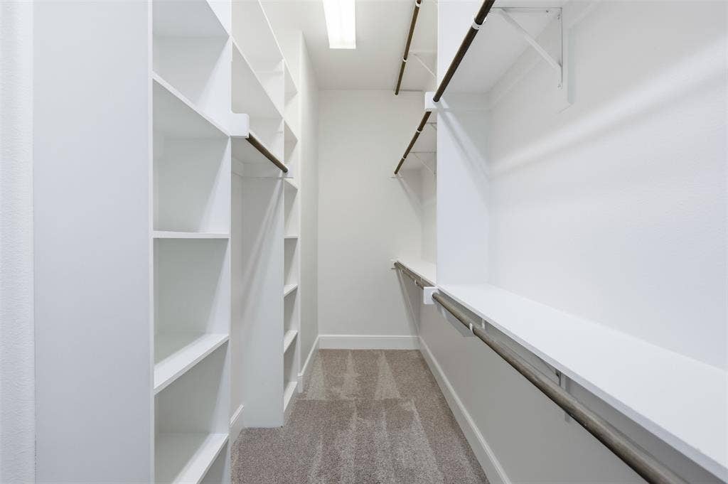 336 Kaye Street, Coppell, TX 75019 Walk-in closet featuring white built-in shelving, tiered hanging rods, and wall-to-wall carpeting