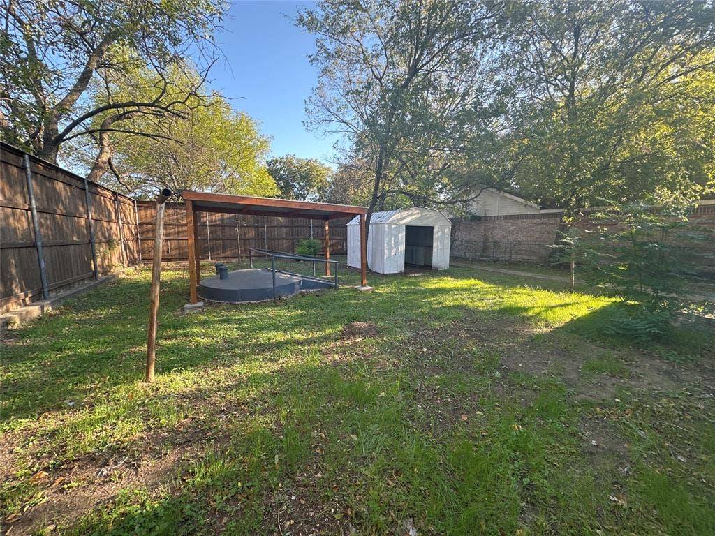 6403 Military Parkway, Dallas, TX 75227 Backyard featuring a storm shelter and a detached metal storage shed