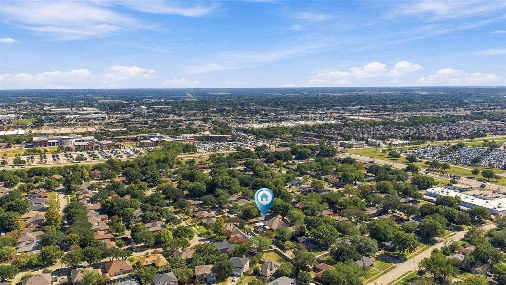 Aerial perspective of the residential property situated within a mature, tree-lined neighborhood