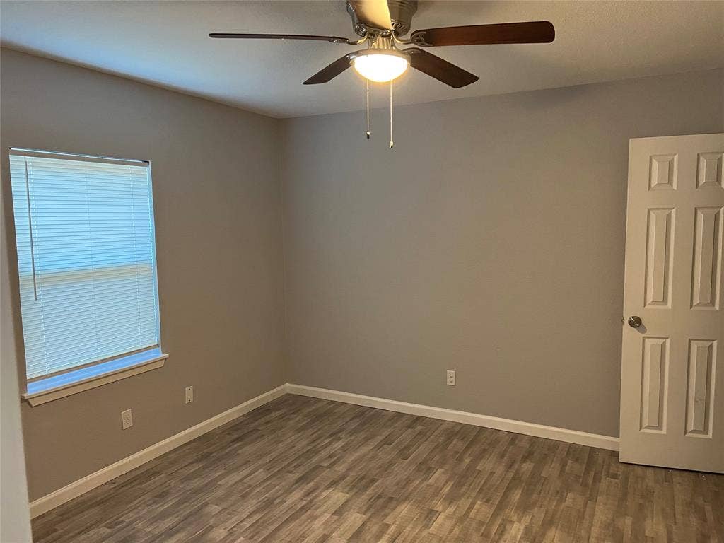 6543 Gentle River, Dallas, TX 75241 Room featuring neutral wall paint, wood-finish flooring, a six-panel interior door, and a ceiling fan with integrated lighting