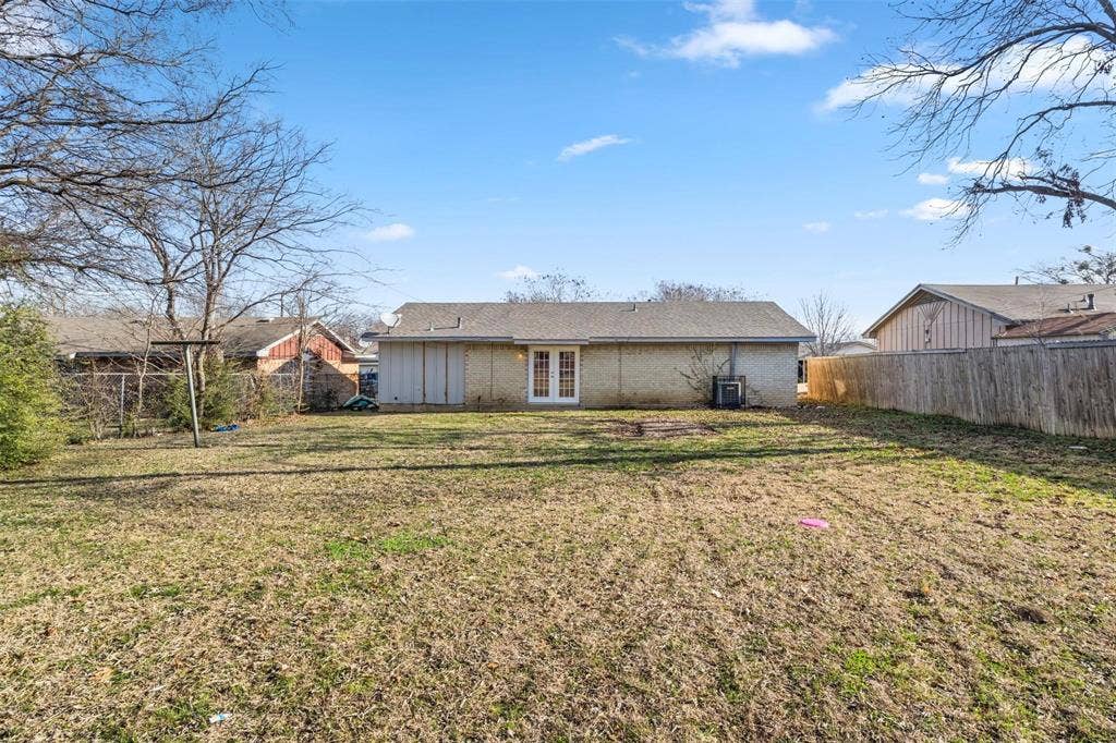 6543 Gentle River, Dallas, TX 75241 Backyard featuring a brick exterior, French doors, wood-plank fencing, and mature trees