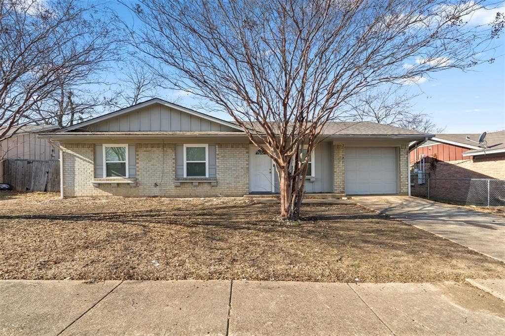 6543 Gentle River, Dallas, TX 75241 Single-story brick exterior featuring a front-facing attached garage, vertical siding accents, and shuttered windows
