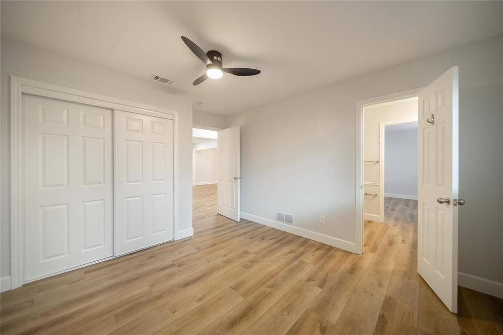 4333 Harvest Hill Road, Dallas, TX 75244 Room featuring wood-finish flooring, a matte black three-blade ceiling fan with integrated lighting, and white six-panel interior doors