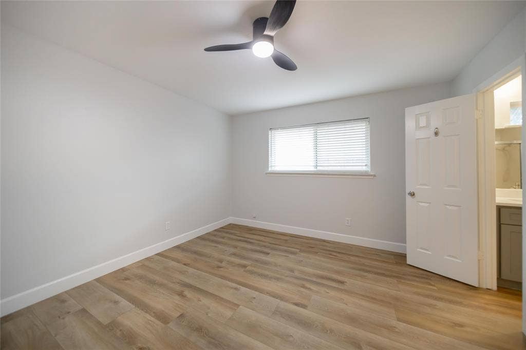 4333 Harvest Hill Road, Dallas, TX 75244 Neutral interior room featuring wood-finish flooring, a modern multi-blade ceiling fan with integrated lighting, and a window with fitted horizontal blinds