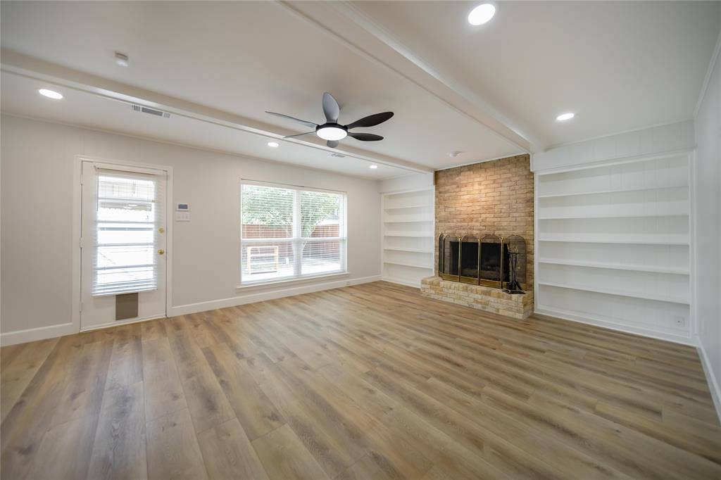 4333 Harvest Hill Road, Dallas, TX 75244 Living area featuring wood-finish flooring, a masonry fireplace with a stone hearth, built-in shelving, a ceiling fan, and recessed lighting