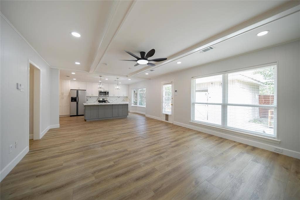 4333 Harvest Hill Road, Dallas, TX 75244 Open-concept space featuring wood-finish flooring, recessed lighting, a center island with contrasting cabinetry, and large windows with horizontal blinds