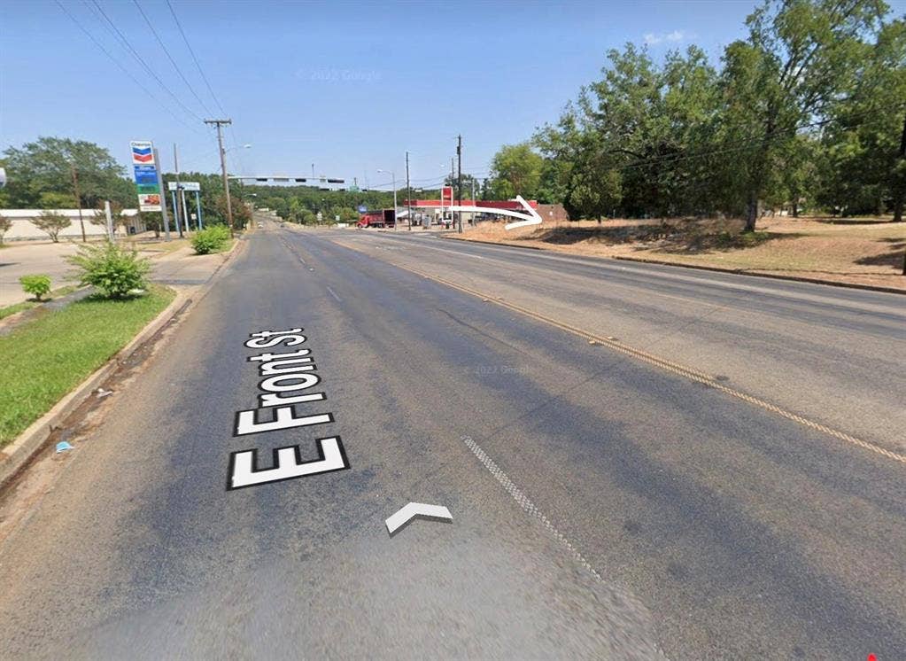 1621 E Front Street, Tyler, TX 75702 Street-level perspective featuring paved roadway frontage, cleared open lot, and mature trees