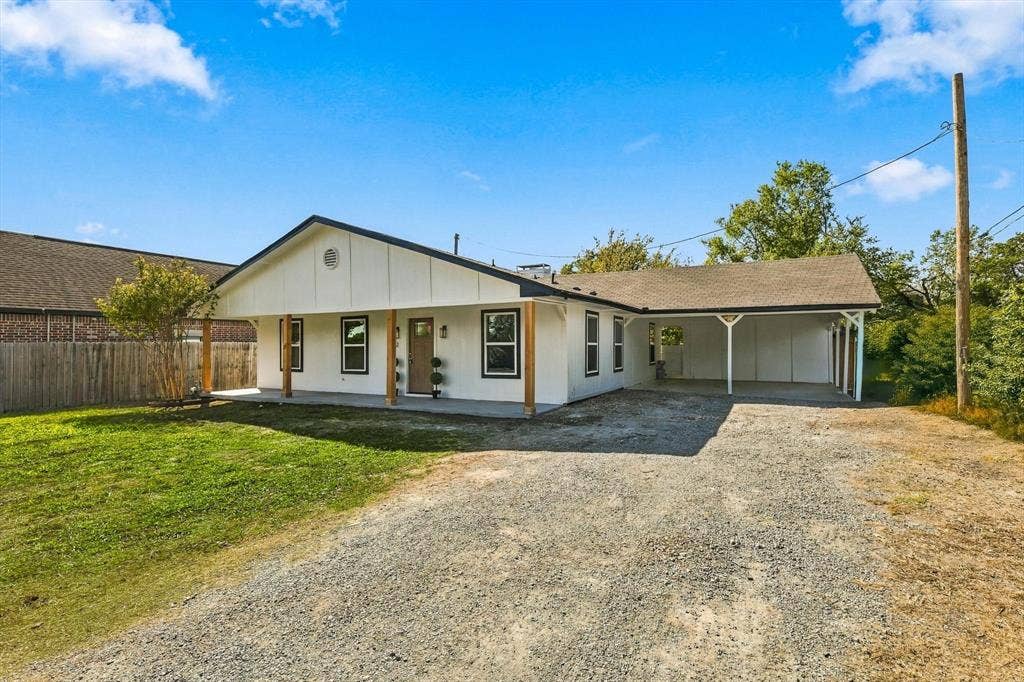 Large driveway with carport large enough for 2 cars.
