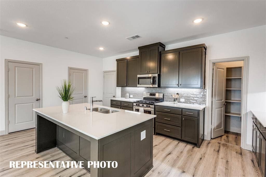 4759 Lunker Street, McKinney, TX 75071 The large kitchen island makes the perfect gathering place for family and friends! REPRESENTATIVE PHOTO.