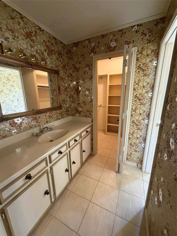 305 Westway Circle, Rockwall, TX 75087 Vanity featuring a solid-surface countertop with an integrated basin, white cabinetry, ceramic tile flooring, and a walk-in storage area with built-in shelving