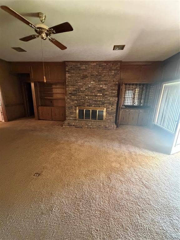 305 Westway Circle, Rockwall, TX 75087 Floor-to-ceiling brick fireplace with a metal insert, built-in wood cabinetry, and a ceiling fan