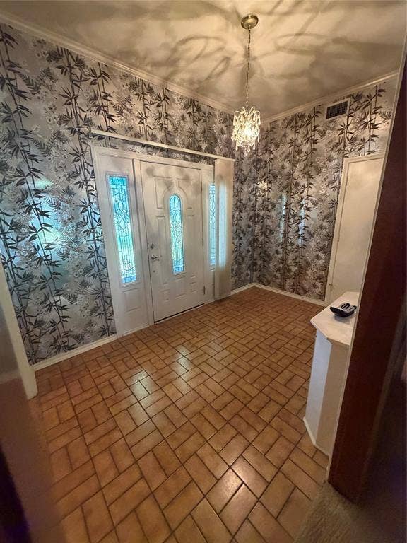 305 Westway Circle, Rockwall, TX 75087 Entryway featuring patterned wallpaper, ceramic tile flooring in a herringbone pattern, a crystal-style multi-arm pendant light, and a white entry door with decorative glass inserts