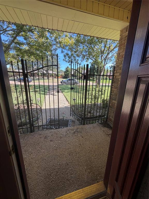 305 Westway Circle, Rockwall, TX 75087 Covered porch featuring a concrete surface, decorative metal security gate, and exterior brick masonry