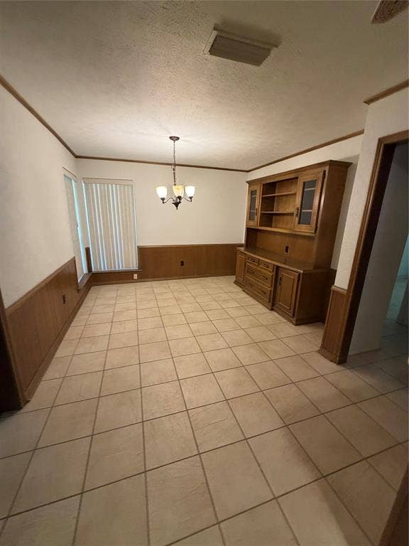 305 Westway Circle, Rockwall, TX 75087 Tiled flooring, wood wainscoting, built-in wooden cabinetry, and a multi-light chandelier