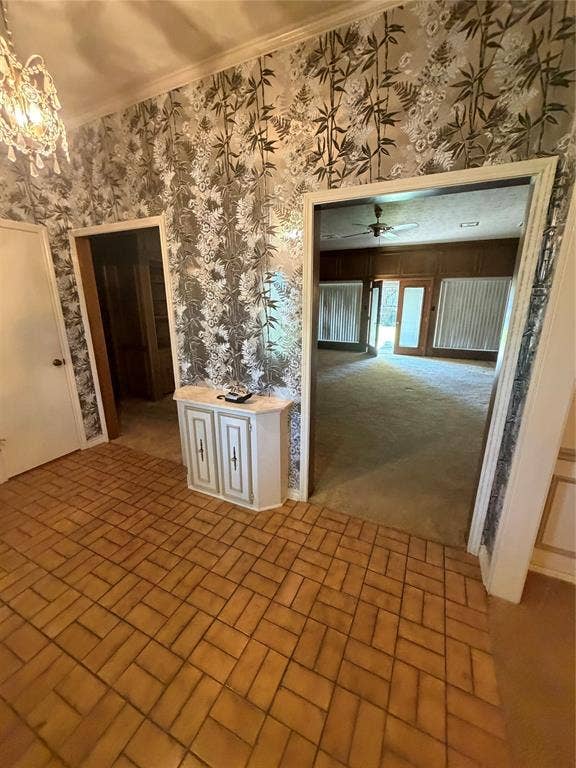 305 Westway Circle, Rockwall, TX 75087 Foyer featuring patterned wall coverings, brick-style flooring, a crystal-style chandelier, and a built-in cabinet with a stone-top surface