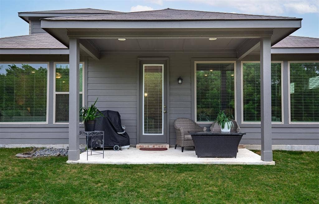 Backyard features covered patio.