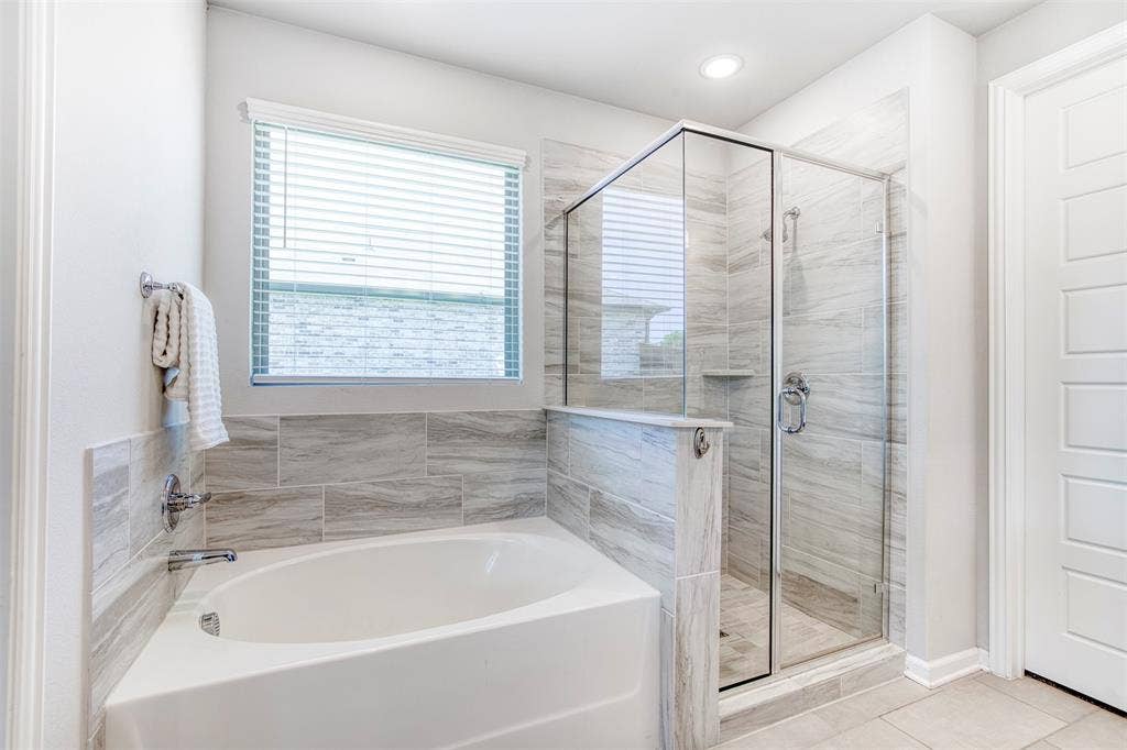 En-suite bath with soaking tub and framed shower.