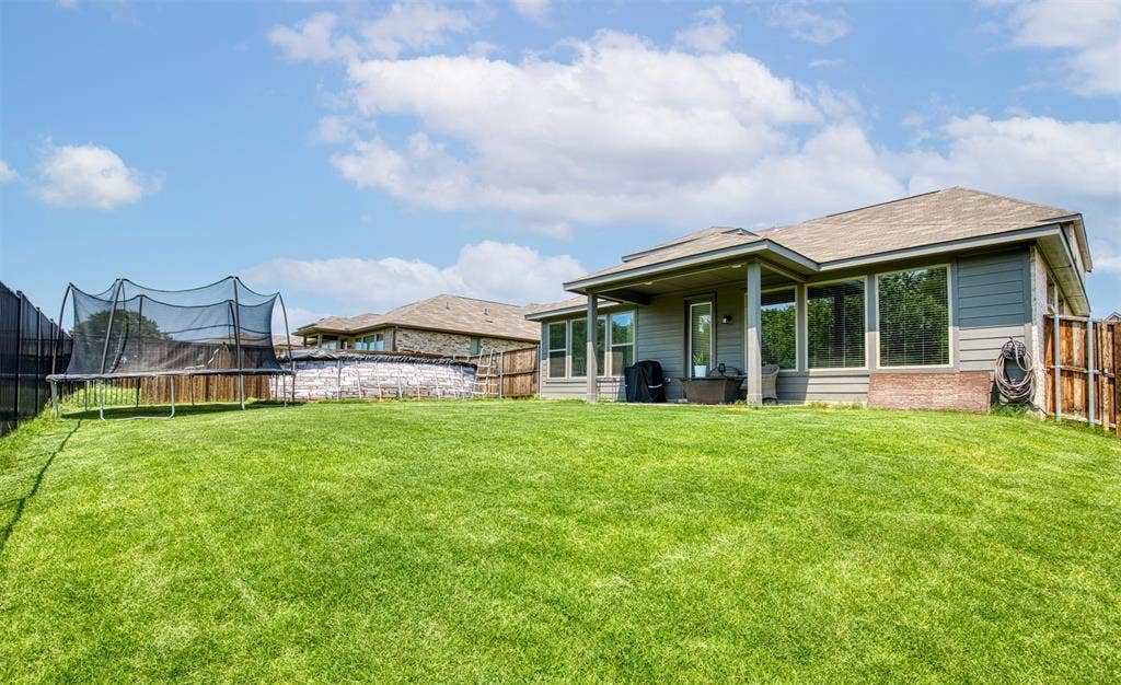Large grassy backyard surrounded by privacy fencing.