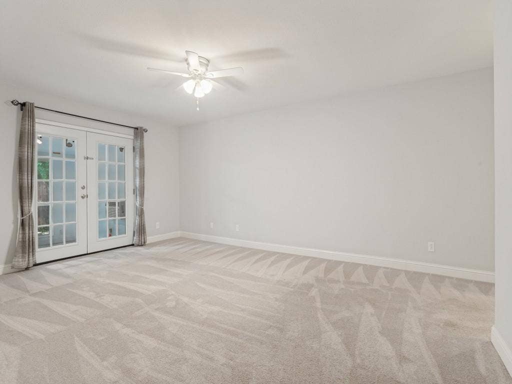 11321 Park Central Place, Dallas, TX 75230 Neutral wall-to-wall carpeting, ceiling fan with integrated lighting, and full-glass panel French doors