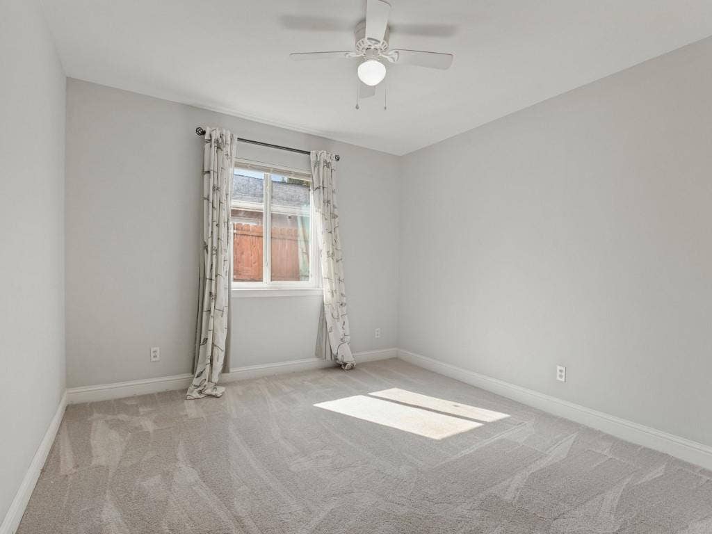 11321 Park Central Place, Dallas, TX 75230 Neutral interior space featuring wall-to-wall carpeting, a multi-blade ceiling fan with integrated lighting, and a single-pane window with a curtain rod