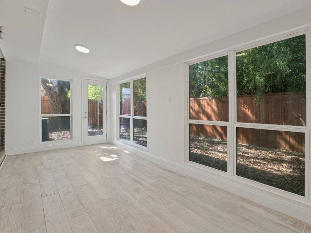 11321 Park Central Place, Dallas, TX 75230 Light-filled room featuring neutral wood-finish flooring, recessed lighting, expansive picture windows, and a glass-paneled exterior door