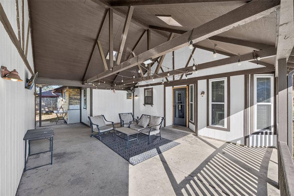 113 Dove Avenue, Red Oak, TX 75154 Covered patio featuring a vaulted ceiling with exposed beams, skylights, and concrete flooring