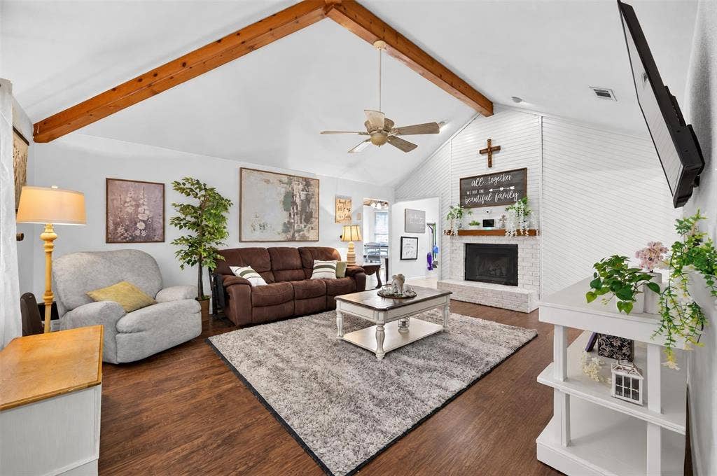113 Dove Avenue, Red Oak, TX 75154 Vaulted ceiling featuring exposed wood beams, wood-finish flooring, and a floor-to-ceiling painted brick fireplace with a wood mantel