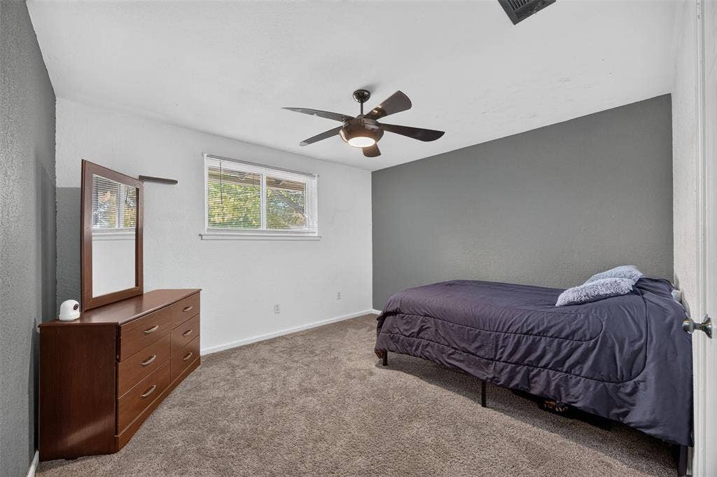 113 Dove Avenue, Red Oak, TX 75154 Neutral-toned carpet flooring, accent wall, ceiling fan with integrated lighting, and horizontal window