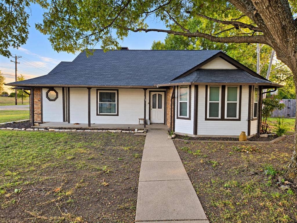 113 Dove Avenue, Red Oak, TX 75154 Single-story exterior featuring painted masonry siding, a covered front porch with support pillars, an extended roofline, a bay window, and a prominent octagon-shaped accent window