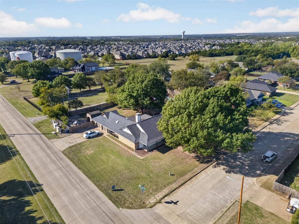 113 Dove Avenue, Red Oak, TX 75154 Aerial perspective of a corner lot property featuring a multi-gabled asphalt shingle roof, masonry exterior, and mature tree canopy