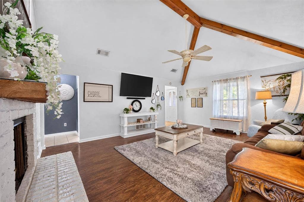 113 Dove Avenue, Red Oak, TX 75154 Vaulted ceilings featuring exposed timber beams, wood-finish flooring, and a floor-to-ceiling painted brick fireplace
