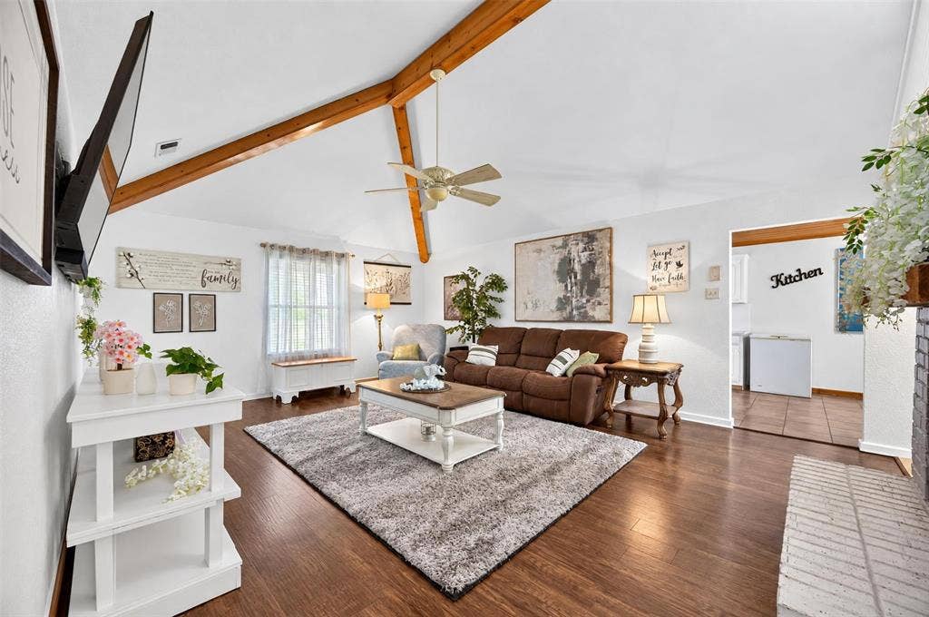 113 Dove Avenue, Red Oak, TX 75154 Vaulted ceiling with exposed wood beams, wood-finish flooring, ceiling fan, and brick fireplace surround