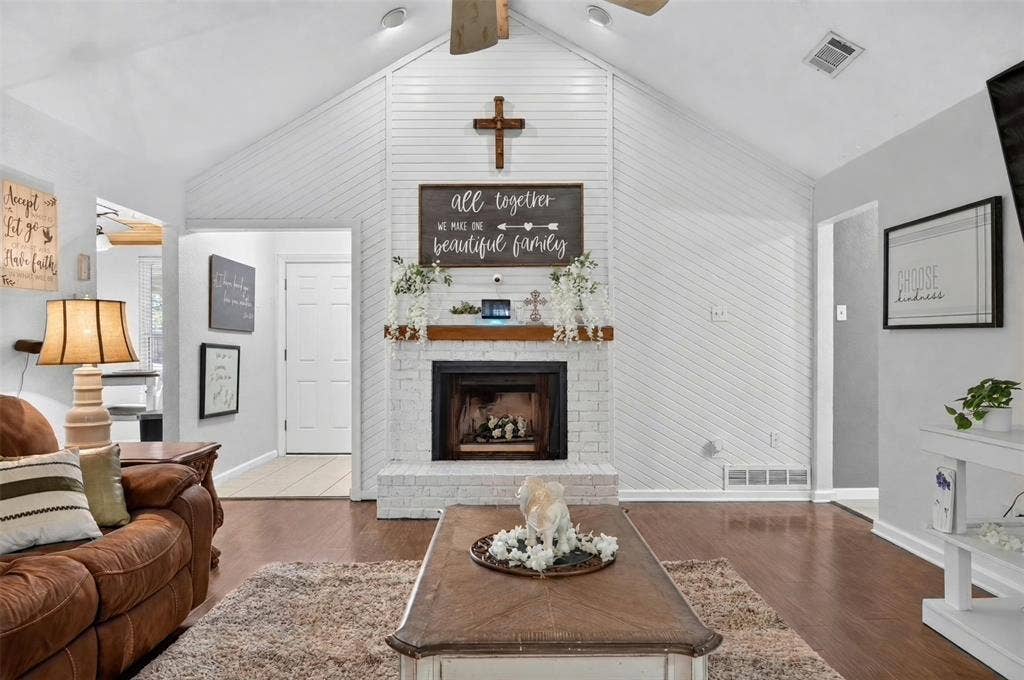 113 Dove Avenue, Red Oak, TX 75154 Vaulted ceilings, painted brick fireplace with a wood mantel, diagonal shiplap accent wall, and wood-finish flooring