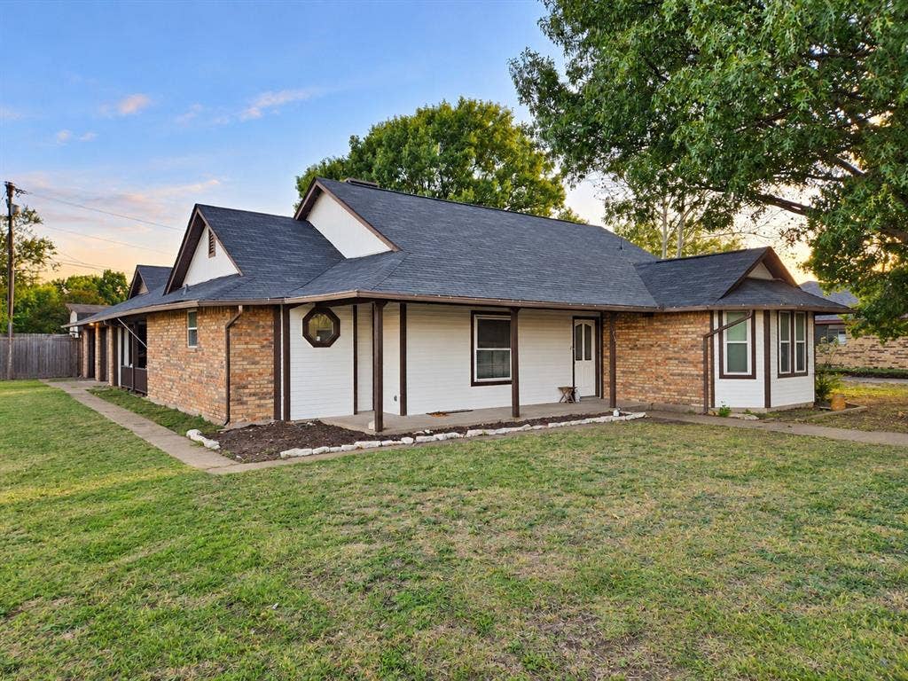 113 Dove Avenue, Red Oak, TX 75154 Exterior featuring a combination of brick and siding, a multi-gabled roofline, a covered wrap-around porch, a decorative octagonal window, and an expansive lawn