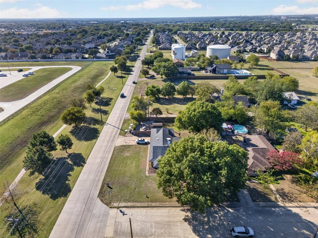 113 Dove Avenue, Red Oak, TX 75154 Aerial perspective featuring a residential lot with mature trees, a rectangular in-ground pool, and a multi-section shingled roof