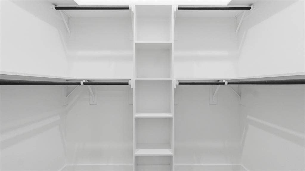 2816 Marburg Street, Dallas, TX 75215 Walk-in closet featuring white built-in shelving, vertical storage tower, and horizontal hanging rods