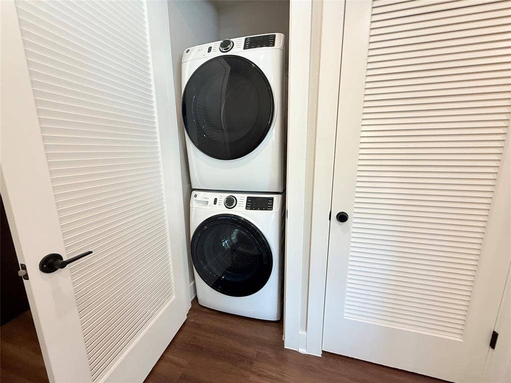 3255 Carlisle Street, #1207, Dallas, TX 75204 Laundry area featuring dark wood finished floors and stacked washer and clothes dryer