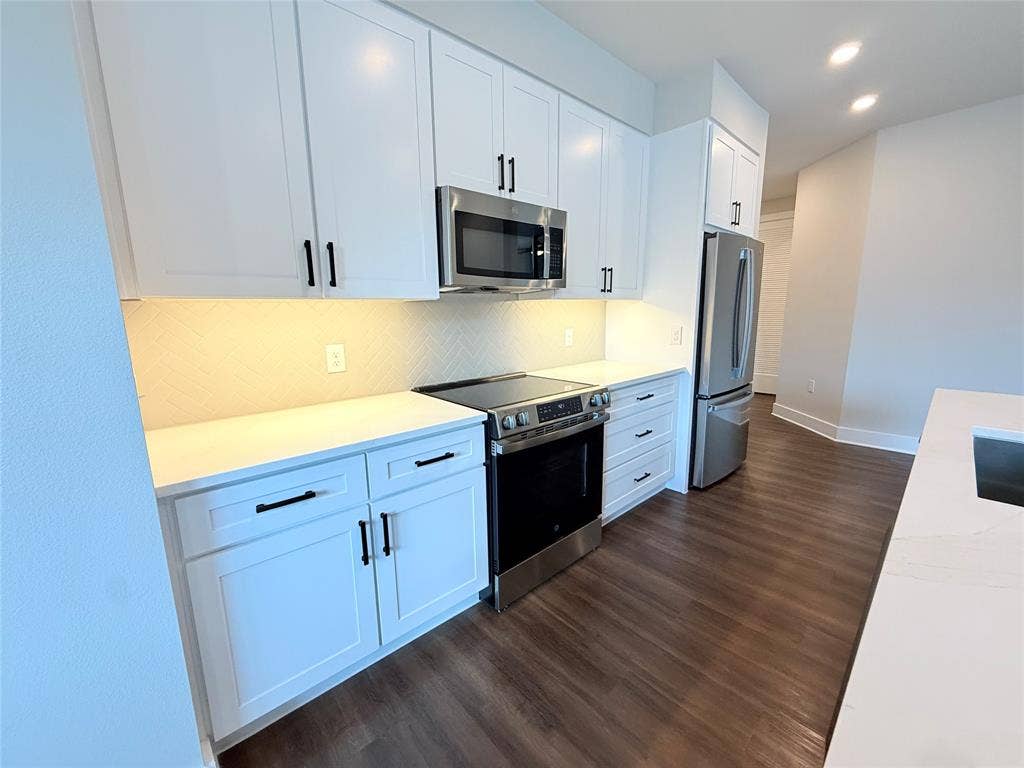 3255 Carlisle Street, #1207, Dallas, TX 75204 Kitchen with appliances with stainless steel finishes, backsplash, white cabinets, dark wood-type flooring, and recessed lighting