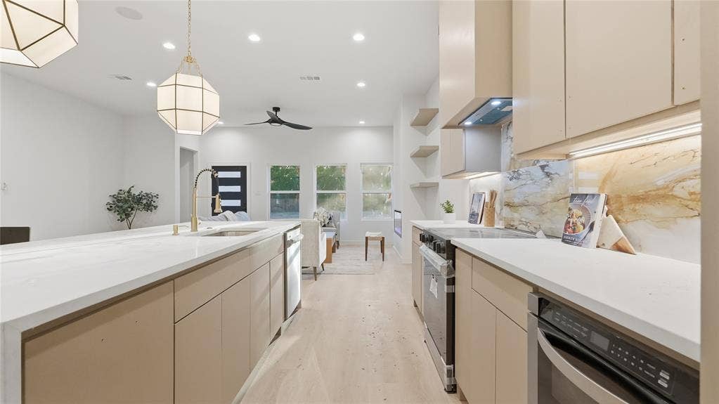 Kitchen featuring wood-finish cabinetry, quartz countertops, geometric pendant lighting, recessed ceiling lights, and a full-height stone backsplash