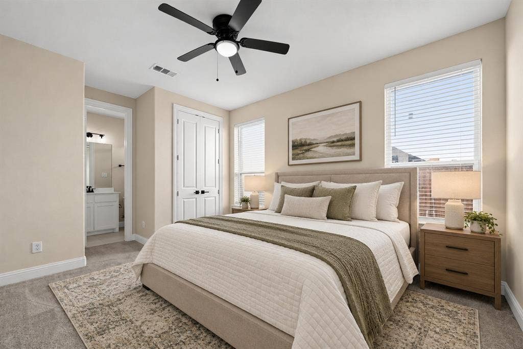 Neutral interior featuring carpeting, double-panel doors with matte black hardware, and a ceiling-mounted light fixture with a fan