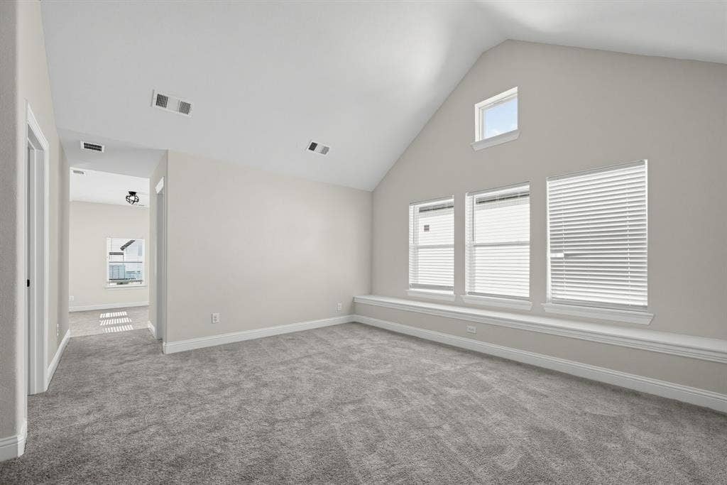 Vaulted ceiling featuring a clerestory window, integrated window bench, and wall-to-wall carpeting